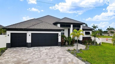 View of front of property featuring an attached garage, stucco siding, decorative driveway, and a front yard