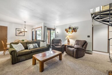 Carpeted living room featuring a notable chandelie