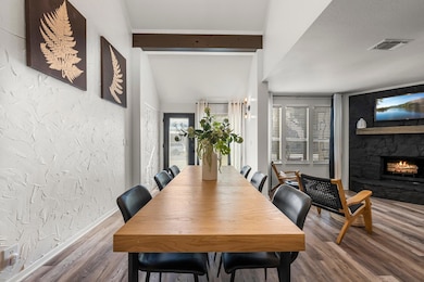Dining area with baseboards, a fireplace, wood fi