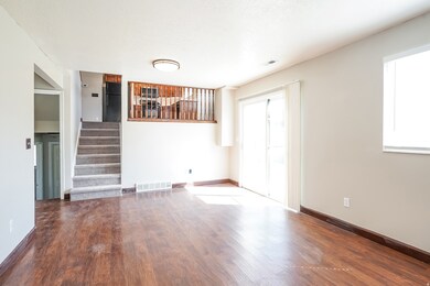 Unfurnished living room featuring wood finished floors and stairway