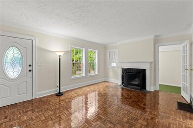 Foyer entrance with a tiled fireplace, baseboards, crown molding, and a textured ceiling