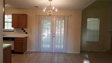 Unfurnished dining area featuring a chandelier and baseboards
