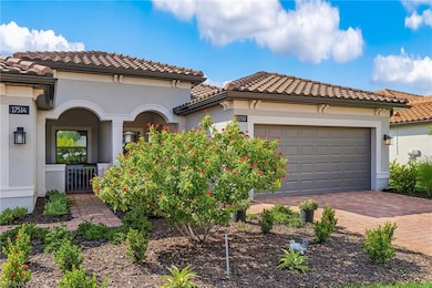 Mediterranean / spanish-style home with a tiled roof, stucco siding, an attached garage, and decorative driveway