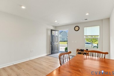 Dining room with light wood finished floors and recessed lighting