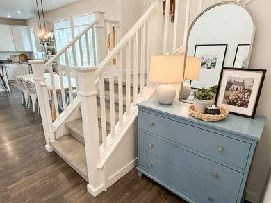 Stairs featuring wood finished floors and a chandelier