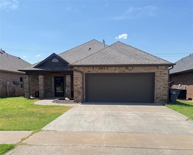 French provincial home featuring a shingled roof, a garage, driveway, and brick siding