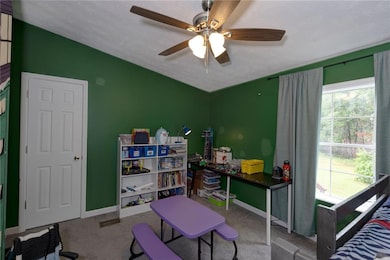 Bedroom featuring carpet floors, vaulted ceiling, and ceiling fan