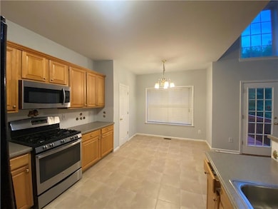 Kitchen featuring appliances with stainless steel finishes, a chandelier, and pendant lighting