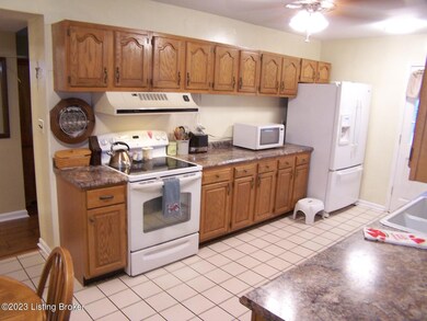 Eat In Kitchen is spacious w/ceramic tile flooring, new ceiling fan/light fixture, 3 other new ceiling lights, lots of cabinets/counter/drawer space, eat-in area for table and chairs, door access to Family Room, rear door to exterior home, newer counter tops and a viewing window into the Family Room.