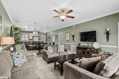 Living room featuring a ceiling fan, ornamental mo