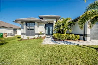View of front of home featuring a front lawn, french doors, and central AC