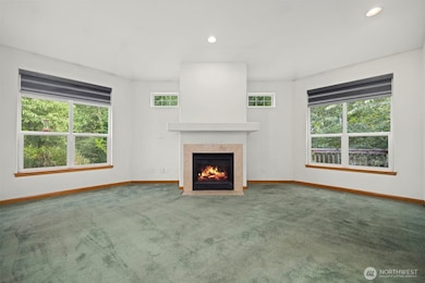 The living room is very spacious and looks out to the greenbelt with a stream running through it.