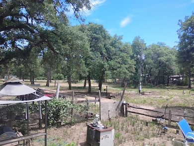 View of yard with fence and view of wooded area