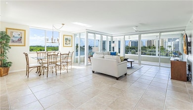 Tiled living room with plenty of natural light, ceiling fan, and floor to ceiling windows