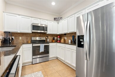 Kitchen features granite countertops, tiled backsp