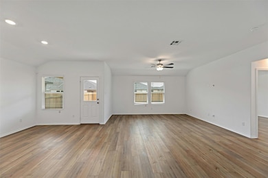 Unfurnished living room featuring plenty of natural light, light wood-style floors, recessed lighting, and ceiling fan