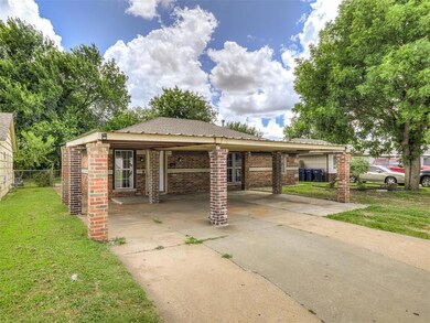 View of front facade featuring an attached carport, brick siding, and concrete driveway