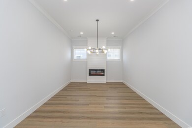 Unfurnished dining area featuring recessed lighting, a fireplace, light wood-style floors, baseboards, and crown molding