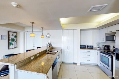 Kitchen with sink, white cabinets, light tile floors, and appliances with stainless steel finishes