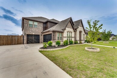 View of front of property with a garage and a front lawn