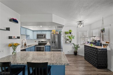 Kitchen featuring blue cabinets, an island, a sink