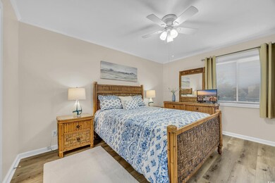 Bedroom with ornamental molding, light hardwood / 