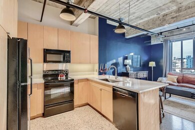 Kitchen with black appliances, light brown cabine