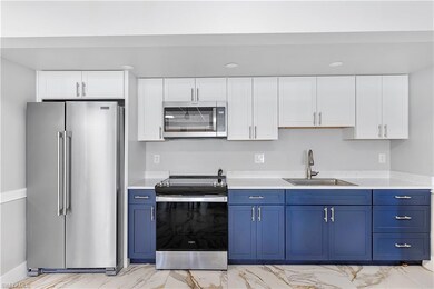 Kitchen with light countertops, appliances with st
