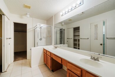 primary bathroom with double sinks and shower and