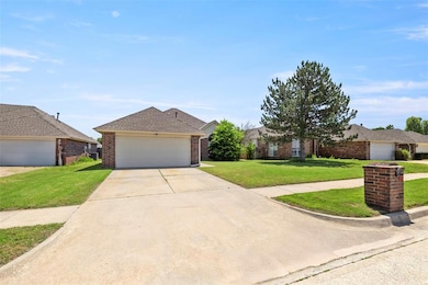 View of front facade with brick siding, a front yard, driveway, and roof with shingles