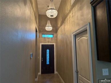 Doorway with a chandelier, dark wood finished floors, and a high ceiling