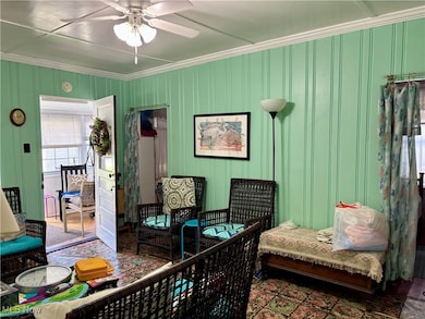 Living room with crown molding and a ceiling fan