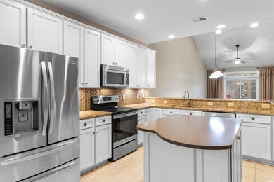 Kitchen featuring white cabinetry, stainless steel