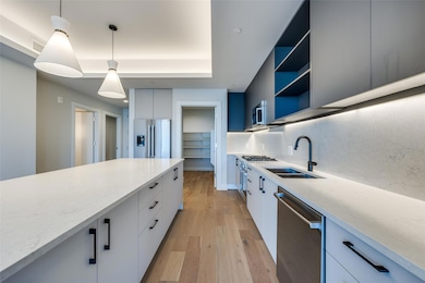 Kitchen featuring pendant lighting, sink, white ca