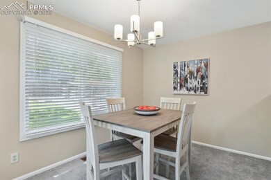 Dining room featuring carpet floors, a chandelier, and baseboards