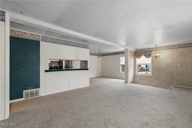 Unfurnished living room with wallpapered walls and light carpet