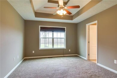 Master bedroom complete with ceiling fan and tray ceiling