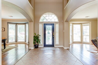 Gorgeous light-filled entry hall opens into the formal living room and formal dining room.  Note the beautiful lead glass door and glass archway.
