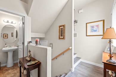 Stairs with baseboards and lofted ceiling