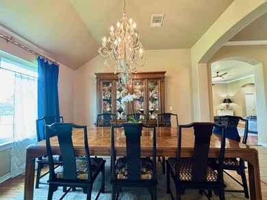 Dining space with arched walkways, a chandelier, crown molding, a ceiling fan, and vaulted ceiling