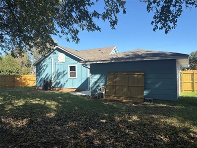 Back of house with a fenced backyard and roof with shingles