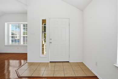 Foyer entrance featuring lofted ceiling and light tile patterned floors