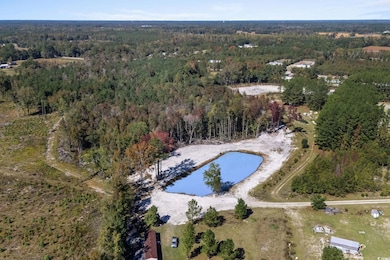 Aerial overview of property's location with a nearby body of water and a forest