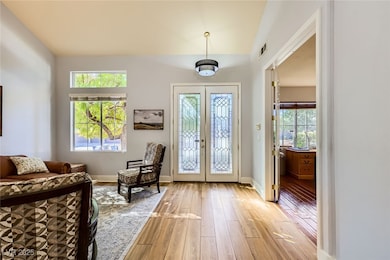 Foyer with baseboards, visible vents, light wood-s