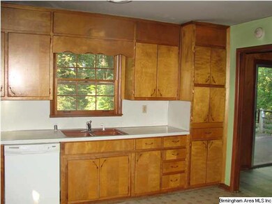 Another view of the kitchen, with stove, dishwashe