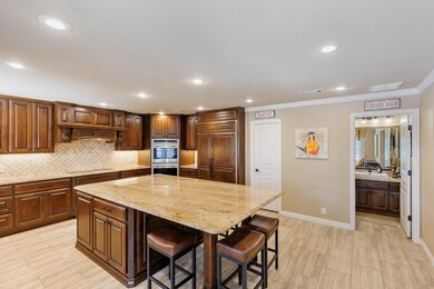 Kitchen featuring double oven, a breakfast bar, l