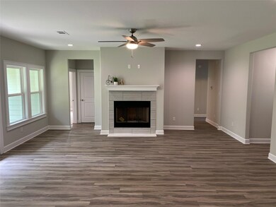 Unfurnished living room featuring ceiling fan, a f