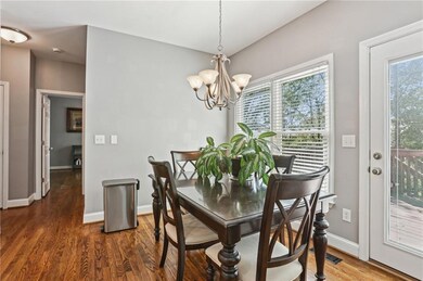 Dining space featuring baseboards, a notable chandelier, and wood finished floors