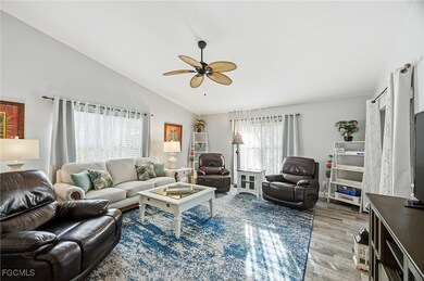 Den with half bath, vaulted ceiling, wood-style tile floors, and ceiling fan
