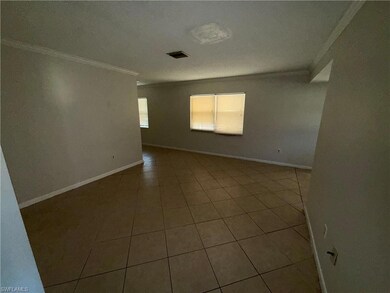 Tiled spare room featuring crown molding